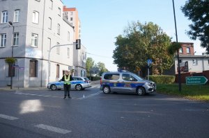 policyjny radiowóz i straży miejskiej blokuje ulicę