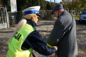 policjantka zakłada opaskę odblaskową mężczyźnie