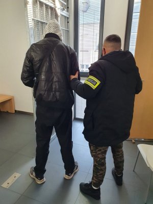 policjant trzyma podejrzanego