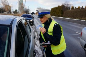 policjantka wręcza kierowcy zawieszkę zapachową