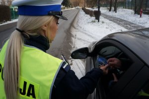 policjantka wręcza kierowcy zawieszkę zapachową