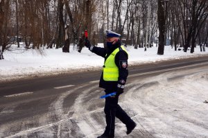 policjant daje sygnał do zatrzymania się