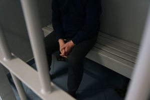 ręce podejrzanego zakute w kajdanki