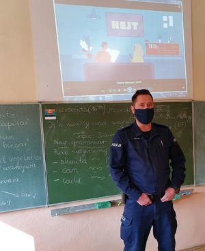 policjant stoi przed tablicą