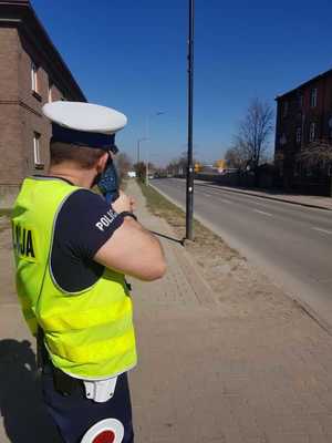 policjant z radarem mierzy prędkość jazdy