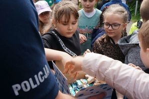 policjant częstuje dzieci cukierkami