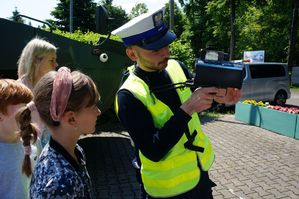 policjant ruchu drogowego pokazuje dzieciom radar