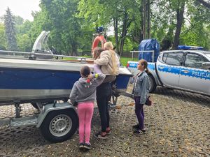 dzieci oglądają policyjną łódź wodną