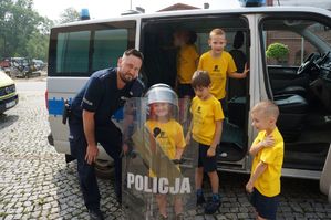 policjant z dziećmi przy radiowozie