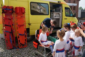 dzieci z ratownikiem medycznym przy karetce
