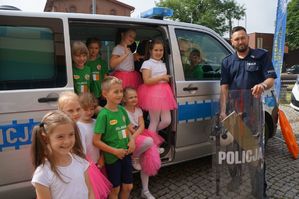 policjant z dziećmi przy radiowozie