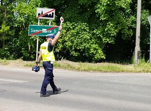 policjant daje sygnał tarczą do zatrzymania pojazdu