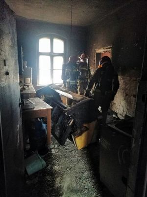 strażacy w spalonym mieszkaniu