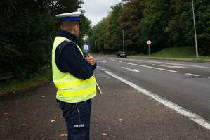 policjant stoi na drodze z radarem