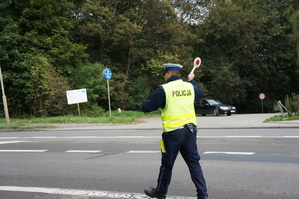 policjant na drodze daje sygnał do zatrzymania pojazdu