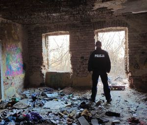 na zdjęciu policjant stoi w pustostanie