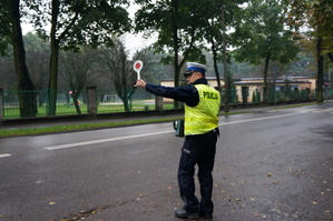 na zdjęciu policjant wydaje polecenie do zatrzymania się kierowcy