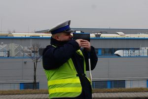na zdjęciu policjant mierzący prędkość radarem