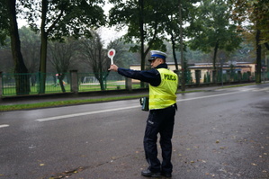 na zdjęciu policjant daje tarczą sygnał do zatrzymania się