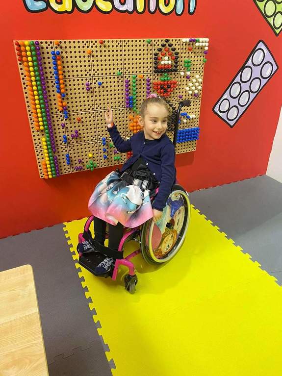 na zdjęciu Julka na wózku inwalidzkim