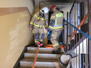 na zdjęciu strażacy na klatce schodowej