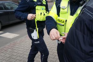 na zdjęciu policjanci wręczają breloki z żetonami z kampanii &quot;Nie reagujesz-akceptujesz&quot;