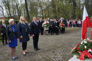 na zdjęciu delegacja władz miasta z wiązanką stoi przed pomnikiem