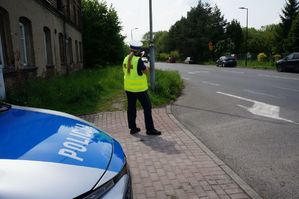 na zdjęciu policjantka mierzy radarem prędkość jazdy pojazdu