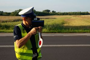 na zdjęciu policjant z drogówki mierzy prędkość