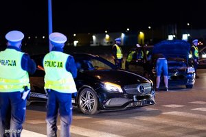 na zdjęciu policjanci kontrolują samochody nocą