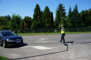 na zdjęciu policjant zatrzymuje samochód