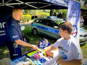 na zdjęciu policjant wręcza odblask dziecku