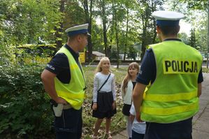 na zdjęciu policjanci z drogówki rozmawiają z uczniami