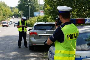 na zdjęciu policjanci z drogówki kontrolują pojazd