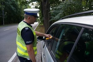 na zdjęciu policjant sprawdza stan trzeźwości kierowcy