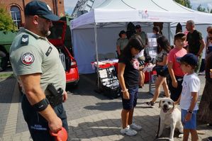 na zdjeciu przewodnik z psem z służby celnej i dzieci