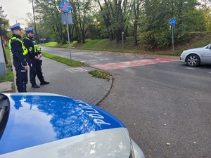 na zdjeciu policjanci z drogówki stoją przy oznakowanych pasach