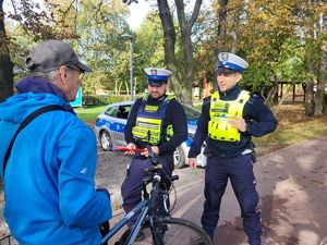 na zdjęciu policjanci wręczają odblaski rowerzyście