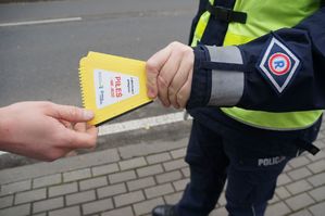 na zdjęciu policjant przekazuje skrobaczkę