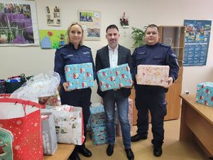 na zdjęciu policjanci i dyrektor MOPS-u trzymają paczki