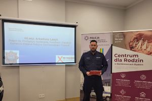 na zdjeciu policjant stoi i przemawia