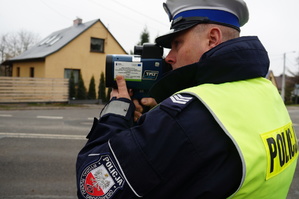 na zdjęciu policjant mierzy prędkość radarem