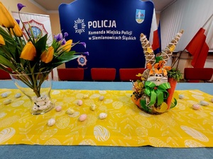na zdjęciu dekoracje świąteczne na stole, a za nimi rollup Komendy Miejskiej Policji w Siemianowicach Śląskich