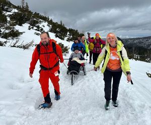 na zdjęciu wolontariusze ciągną na sankach Skarba