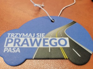 na zdjeciu zawieszka w kształcie auta i napis trzymaj się prawego pasa