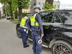 na zdjęciu policjanci stoją przy kontrolowanym samochodzie