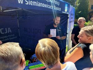 na zdjęciu policjant trzyma ulotkę KMZB