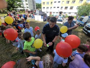 na zdjęciu policjant rozdaje dzieciom odblaski