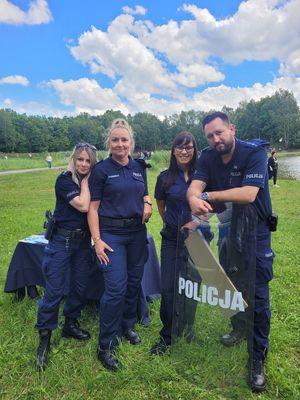 na zdjęciu policjanci i strażniczka stoją z tarczą ochronną