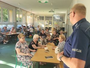 na zdjęciu policjant rozmawia z mieszkańcami